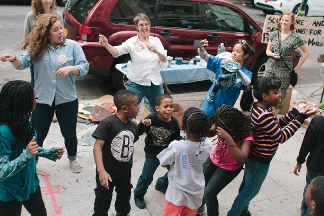 Youth dance on the the sidewalk of Kelly Street, a block in Longwood, Bronx.