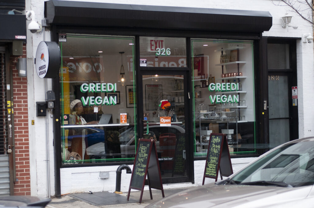 A photograph of the storefront of Greedi Vegan restaurant looking inviting and fresh!