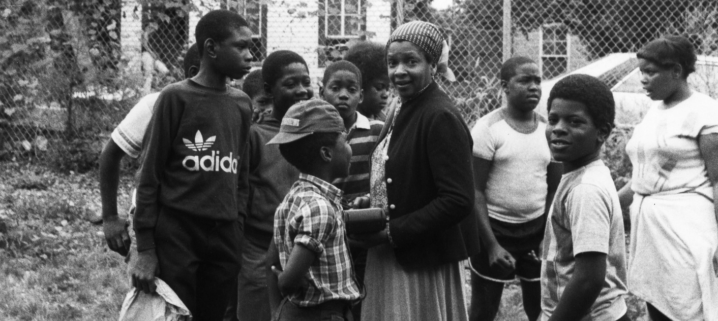 Joan Maynard gathered outside with children (Black & White photo)